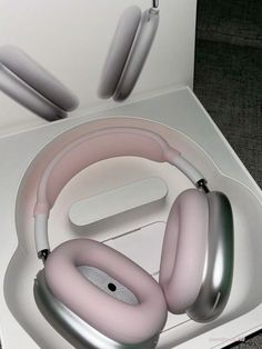 a pair of headphones sitting on top of a white box next to ear buds