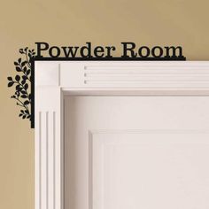 a sign that says powder room on the side of a door with leaves and branches