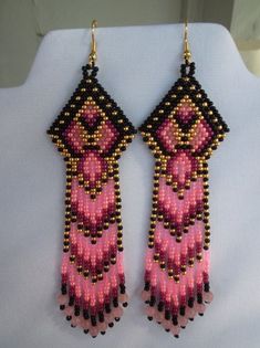 pink and black beaded earrings hanging from a mannequin's neckline