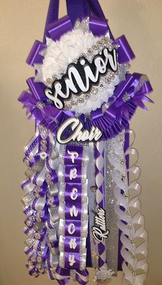 a purple and white ribbon hanging from the side of a wall with words on it