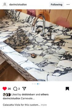 an image of a bathroom sink with marble counter top and faucet in the middle