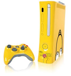 a yellow nintendo wii game controller next to a cardboard box with an image of a cartoon character on it