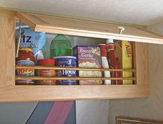 a wooden shelf filled with lots of food and condiments on top of it