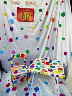 two colorful polka dot chairs in front of a white backdrop