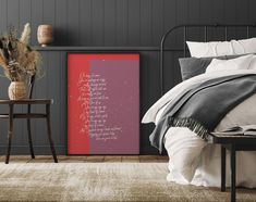 a bedroom with grey walls and white bedding has a pink poster on the wall