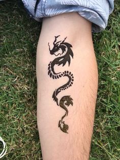 a person with a tattoo on their leg that has a dragon drawn on the side