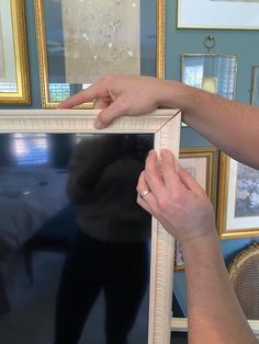 two hands holding up a white framed television