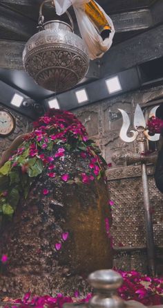 the inside of a building with flowers on the ground and decorations hanging from the ceiling