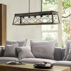 a living room filled with furniture and a light fixture hanging over the top of it