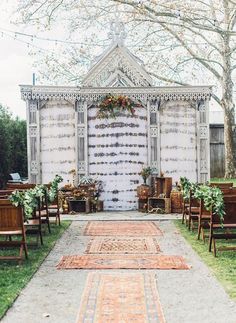 an outdoor ceremony set up with chairs and rugs