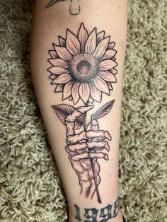 a tattoo on the leg of a person with a sunflower in their hand and writing i love you