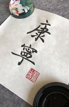 a piece of paper with chinese writing on it next to a cup and saucer