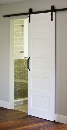 an open white door in a room with wood floors