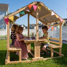 two children are sitting at a picnic table