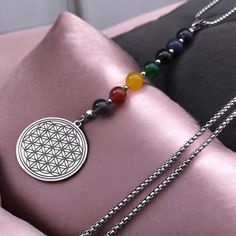 the flower of life necklace is adorned with multicolored beads and a silver pendant