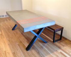 a table and bench in a room with hard wood floors