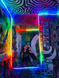 a woman taking a selfie in a room with neon lights