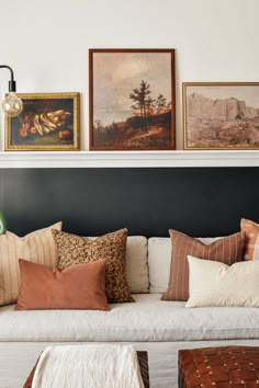 a living room filled with lots of pillows and pictures on the wall above it's headboard