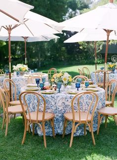 an outdoor table set up with blue and white linens