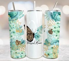 two stainless steel tumblers with butterflies and flowers on them, one has a straw in it