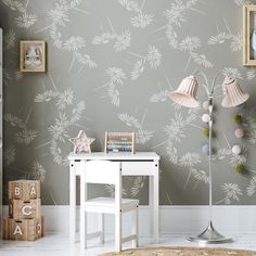 a white table sitting in front of a gray wall with a lamp on top of it