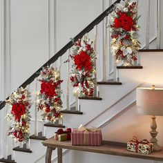 christmas decorations on the banisters and stairs in a home decorated with red poinsettias