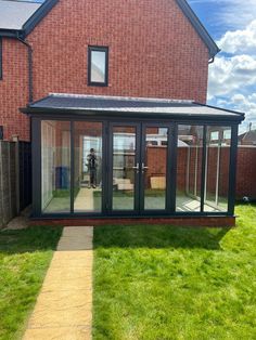 a brick house with glass walls and doors