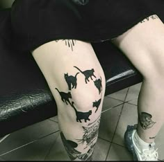 a person sitting on a bench with tattoos on their legs and leggings that have cats all over them