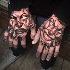 two hands that have tattoos on them with faces painted on the palms and one is wearing a mask