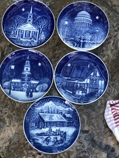 four blue and white plates sitting on top of a stone counter next to an american flag