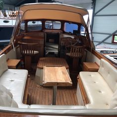 the inside of a boat with wooden tables and chairs