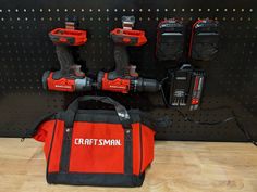 a tool bag sitting on top of a wooden floor next to two power drillers