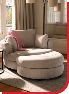 a living room filled with furniture and a large round ottoman in front of a window