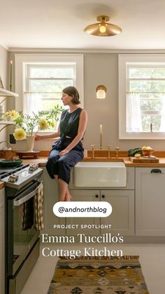 a woman sitting on the edge of a kitchen counter next to a stove top oven