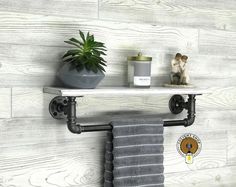 a towel rack with two towels and a potted plant