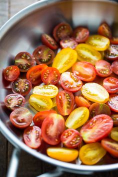 a pan filled with sliced tomatoes on top of a wooden table