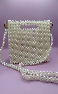 Handmade bead bag in ivory pearl with a gold accent🤍🕊️ All handbags are unique in design and color. Custom requests accepted with 3 months lead-time.  Satisfaction guaranteed.  Returns and exchanges accepted within 21 days of delivery. Square Shoulder Bag With Pearl Handle, Pearl Handle Tote Bag For Gift, Square Bags With Pearl Handle For Everyday Use, White Rectangular Shoulder Bag With Pearl Handle, Cream Rectangular Shoulder Bag With Pearl Handle, White Shoulder Bag With Pearl Handle, Elegant Square Box Bag With Pearl Handle, White Square Shoulder Bag For Party, Gift Tote Bag With Pearl Handle