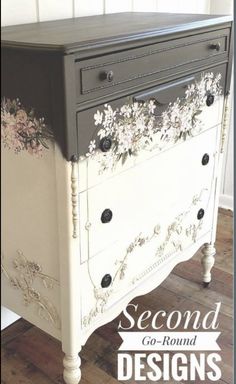 an old dresser with flowers painted on the top and bottom, sitting in a room