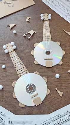 a wooden table topped with lots of musical instruments and sheet music paper cut outs on top of it