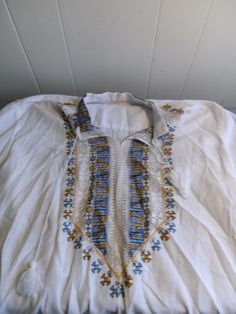 There is a small spot on the front and one the sleeve. This is pre owned and looks barely worn. Fabric feels linen but there is no fabric label. 32 long. 24" pit to pit. It has an attic storage smell and needs to be laundered. The string on one sleeve end is longer on one sleeve, see pics. Embroidered Cross, Attic Storage, Fabric Labels, Tunic Shirt, Favorite Outfit, Gender Neutral, Cross Stitch, Bathing Beauties, Adult Outfits