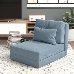 a blue chair sitting on top of a white rug