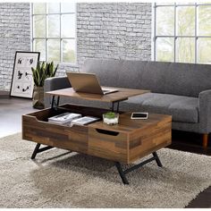 a living room with a couch, coffee table and laptop