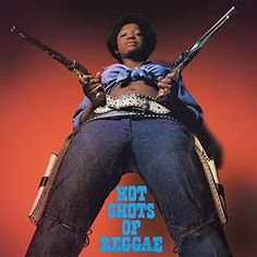 a woman holding two shotguns while standing in front of a red wall with the words hot shots of reggae written on it