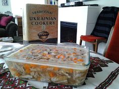 a casserole dish on a table in front of a book about traditional ukraine cookery