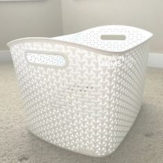 a white plastic basket sitting on the floor