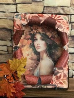 a photo frame sitting on top of a wooden shelf next to a leafy plant