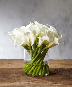 white flowers in a glass vase on a wooden table