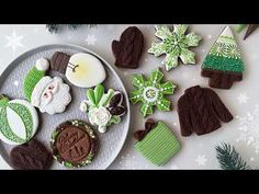 some cookies are on a white plate and decorated with green, brown and white decorations