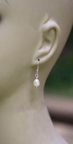 "White fresh water pearl sterling silver dangle earrings 5x7mm white fresh water pearls are wrapped in sterling silver dangling from budded sterling silver hooks. Measure 1 ¼\" long" Tiny Elegant Pearl Earrings For Gifts, Handmade Dainty Pearl Earrings, Dainty Pearl White Earrings With Ear Wire, Dainty Pearl White Pearl Earrings, Dainty Handmade Pearl Earrings, Handmade Sterling Silver Pearl Earrings For Wedding, Simple Silver Pearl Drop Jewelry, Delicate Nickel-free Sterling Silver Pearl Earrings, Delicate Pearl Earrings With Ear Wire In Sterling Silver