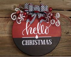 a red and black sign that says hello christmas with bows on the top, hanging on a wooden wall